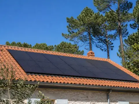 Panneaux solaires noirs posés sur une toiture en tuiles